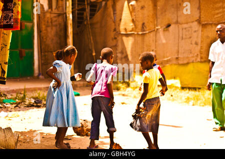 MOMBASA, KENIA. 18. Dezember 2011: Eine Gruppe kenianischer Kinder spielen auf der staubigen Straße in Mombasa, Kenia. Stockfoto