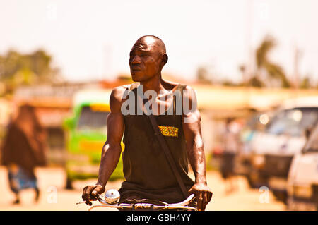 MOMBASA, KENIA. 18. Dezember 2011: Ein magerer kenianischen Mann fährt Rad Push durch die Straßen von Mombasa, Kenia. Stockfoto