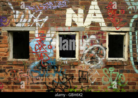 Graffiti und Vandalismus auf verlassenen verfallenen Industriegebäude. Stockfoto