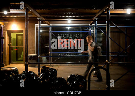 Ein Mann geht vorbei an einer leeren Store mit einem Schild "Store zu vermieten" im Fenster "" New York, USA, 13. Mai 2009. Stockfoto