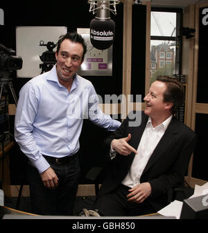 Gastgeber der Frühstücksshow Christian O'Connell (links) mit Gast, konservativer Führer David Cameron, im Absolute Radio im Zentrum von London. Stockfoto