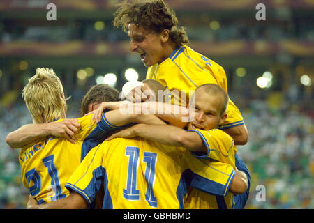 Fußball - UEFA-Europameisterschaft 2004 - Gruppe C - Schweden - Bulgarien. Die schwedischen Spieler feiern Henrik Larssons zweites Tor Stockfoto