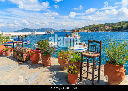 Blume Töpfe auf und Anzeigen der Angelboote/Fischerboote ankern in Kokkari Bucht, Insel Samos, Griechenland Stockfoto