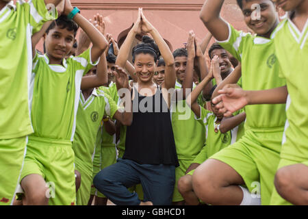 Frau, Yoga-Unterricht mit Kindern Studenten in Neu-Delhi, Indien. Stockfoto