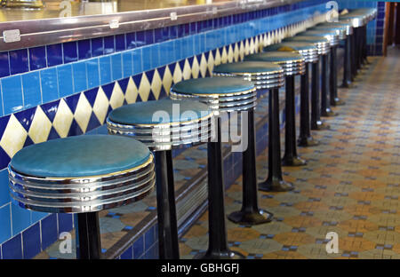 Reihe von Chrom und blau Leder Hocker in retro-Diner. Stockfoto