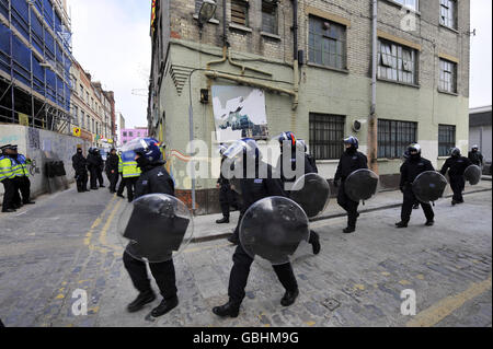 Metropolitan Police Officers führen eine Razzia auf einem Haus in Rampart Street im Osten Londons durch. Die Razzia ist mit Gewalt bei den G20-Protesten verbunden. Stockfoto