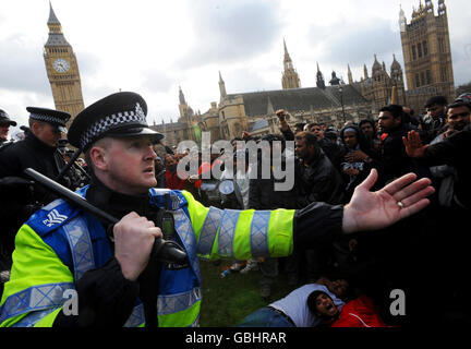 Polizeibeamte halten tamilische Demonstranten zurück, während sie heute Morgen den Londoner Parlamentsplatz besetzen, um einen sofortigen Waffenstillstand in Sri Lanka zu fordern. Stockfoto