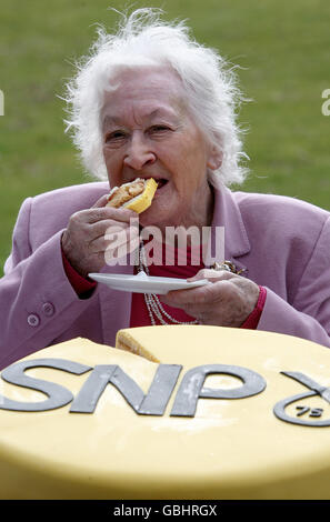 Winnie Ewing, Mitglied der Scottish National Party, ehemaliger Europaabgeordneter und Abgeordneter, hat an der Stirling University ein Stück Geburtstagstorte zum 75. Jahrestag der Gründung der SNP. Stockfoto