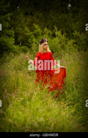 Blonde romantische Fee Elfe Modell in Wiese mit mit gold lila rose Krone Kopfschmuck, kontemplative, dramatische Stockfoto