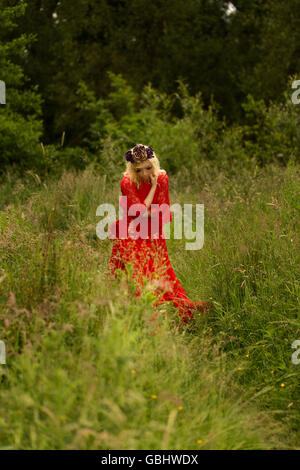 Blonde romantische Fee Elfe Modell in Wiese mit mit gold lila rose Krone Kopfschmuck, kontemplative, dramatische Stockfoto