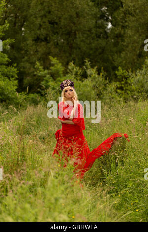 Blonde romantische Fee Elfe Modell in Wiese mit mit gold lila rose Krone Kopfschmuck, kontemplative, dramatische Stockfoto