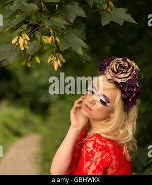 Blonde romantischen präraffaelitische Fee Elfe Modell, barfuß mit lila rose Goldkrone Kopfschmuck, kontemplative im herbstlichen Wald Stockfoto