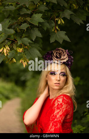 Blonde romantischen präraffaelitische Fee Elfe Modell, barfuß mit lila rose Goldkrone Kopfschmuck, kontemplative im herbstlichen Wald Stockfoto