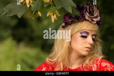 Blonde romantischen präraffaelitische Fee Elfe Modell, barfuß mit lila rose Goldkrone Kopfschmuck, kontemplative im herbstlichen Wald Stockfoto