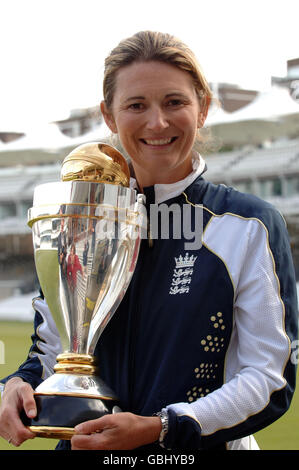 Die Cricket-Captain Charlotte Edwards der englischen Frauen hält die Trophäe, als sie nach einer Pressekonferenz auf dem Lord's Cricket Ground, London, von dem Team begleitet wird. Stockfoto