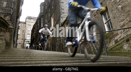 Die Teilnehmer fahren mit dem Fahrrad durch Warriston Close Steps in Edinburgh, um das Edinburgh Rat Race zu fördern. Stockfoto