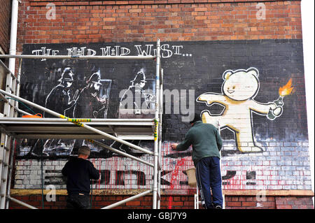 Zwei Künstler aus der Peoples Republic of Stokes Croft arbeiten an der Reinigung von roter Farbe, die verwendet wurde, um ein Banksy-Kunstwerk Anfang 1999 an der Seite eines Barberladens in Stokes Croft, Bristol, zu zerstören. Stockfoto