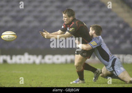 Phil Godman aus Edinburgh entlastet den Ball unter dem Druck von Cardiff Blues' Ceri Sweeney (rechts) Stockfoto