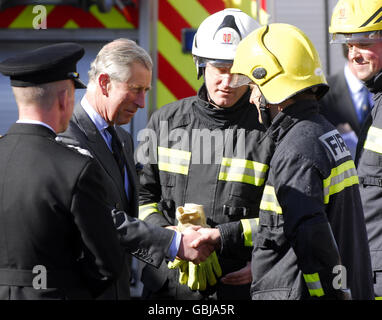 Der Prinz von Wales (links) spricht mit Mitgliedern des Prinzen Trust, die mit der Feuerwehr trainieren durften, während eines Besuchs in Poundbury, wo er das neue Dorset Fire and Rescue HQ in poundbury, Dorset, eröffnete. Stockfoto