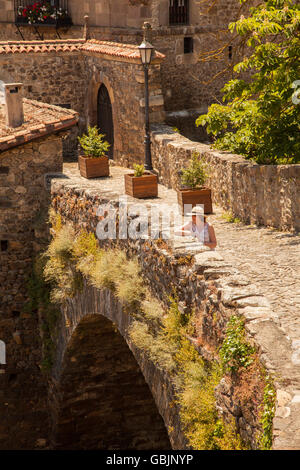 Frau mit Hut stehend auf die mittelalterliche Brücke von San Cayetano über den Fluss Deva in der spanischen Stadt Jávea in die Picos de Europa Spanien Stockfoto