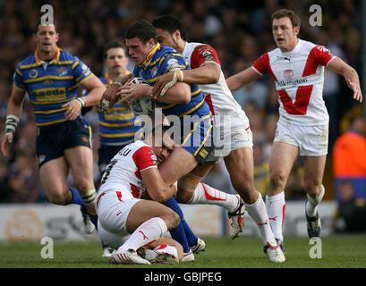 Luke Burgess von Leeds Rhinos wird von St. Helens' Maurie Fa'asavalu und Tony Puletua angegangen. Stockfoto