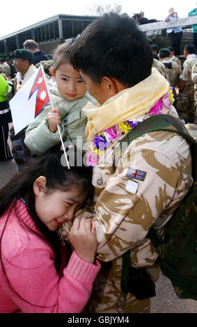 Colour Sergeant David Rai begrüßt seine Töchter Sweta (oben), die heute drei Jahre alt ist, und Mahima (unten), da rund 120 Mitglieder des 2. Bataillons der Royal Gurkha Gewehre nach ihrer Rückkehr aus der Provinz Helmand in Afghanistan in ihre Kaserne in Folkestone, Kent, zurückkehren. Stockfoto