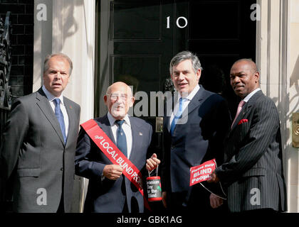 Premierminister Gordon Brown (zweiter rechts) wird von (links nach rechts) Greater London Fund for the Blind (GLFB) Chairman, David Hawkins, Vice President von GLFB, Sir Stirling Moss, und GLFB CEO Cass Edwards zum Geranium Day vor der Downing Street 10 begleitet. Stockfoto