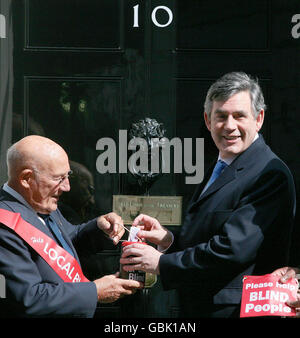 Sir Stirling Moss, Vizepräsident von GLFB, nimmt die traditionelle Spende des Premierministers Gordon Brown zum Geranium Day vor der Downing Street 10 entgegen. Stockfoto