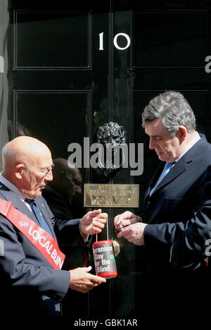 Sir Stirling Moss, Vizepräsident von GLFB, nimmt die traditionelle Spende des Premierministers Gordon Brown zum Geranium Day vor der Downing Street 10 entgegen. Stockfoto