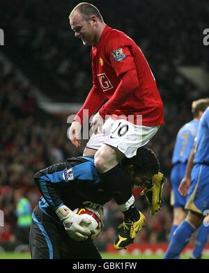 Portsmouth-Torhüter David James behauptet den Ball vor Manchester United's Wayne Rooney Stockfoto