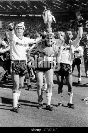 Steve Foster (l) von Luton Town und Brian Stein (r), die zwei Tore schossen, Krontorwart Andy Dibble (c), der eine Arsenal-Strafe rettete, mit dem Littlewoods Cup nach ihrem Sieg von 3-2 Stockfoto