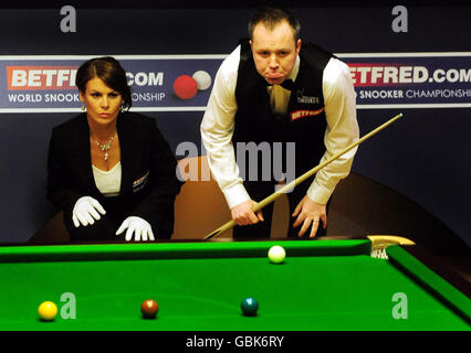 Schottlands John Higgins (rechts) mit Schiedsrichterin Michaela Tabb während des Finales der Snookerweltmeisterschaft Betfred.com im Crucible Theatre, Sheffield. Stockfoto