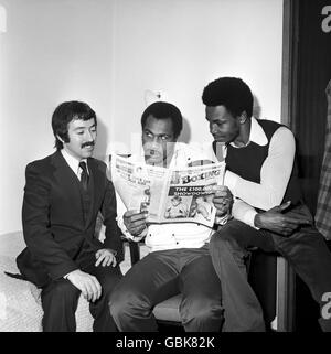 Boxen. Ken Norton (c) liest die Boxing News mit dem Herausgeber Graham Houston (l) und Hedgemon Lewis (r) Stockfoto