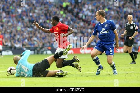 Danny Welbeck von Manchester United (links) geht unter einem Tackle nach unten Von Evertons Phil Jagielka, aber keine Strafe wird von gegeben Schiedsrichter Mike Riley (ganz rechts) Stockfoto