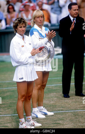 Tennis - Wimbledon Championships - Dameneinzel - Finale - Martina Navratilova gegen Chris Evert Lloyd. Martina Navratilova (r) und Chris Evert Lloyd (l) applaudieren unbegeistert, als der Schiedsrichter nach dem Finale seine Medaille erhält Stockfoto