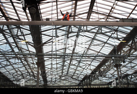 Ein Bahnarbeiter auf einer Gantry auf dem Dach des Waverley-Bahnhofs in Edinburgh. Der Bahnhof wird bald 130 Millionen Dollar überholen, wobei ein neuer Eingang sowie Verbesserungen an einigen Plattformen, Concourses und Gehwegen vorgesehen sind. Stockfoto