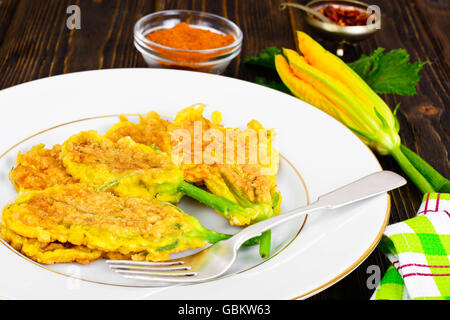 Blüten der Zucchini, Fried im Teig auf einem hölzernen Hintergrund Stockfoto