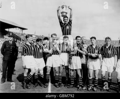 Manchester City Kapitän Roy Paul (TOP) hält den FA Cup nach dem Sieg seines Teams im Jahr 3-1 hoch, während seine Teamkollegen für die Kameras posieren: (l-r) Roy Little, Bobby Johnstone, Dave Ewing, Don Revie, Ken Barnes, Roy Clarke und Jack Dyson. Stockfoto