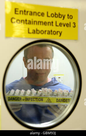 Ein Wissenschaftler behandelt Virusproben im West of Scotland Specialist Virology Centre am Gartnavel General Hospital, Glasgow, wo er Grippeproben auf Spuren der Schweinegrippe untersucht hat. Stockfoto