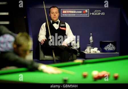 Der schottische John Higgins beobachtet die nordirische Marke Allen während der Snookerweltmeisterschaft Betfred.com im Crucible Theatre, Sheffield. Stockfoto