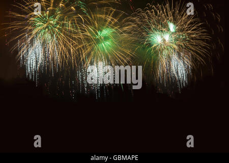 Goldenen und grünen Feuerwerk über dem Nachthimmel. Buntes Feuerwerk feiern. Urlaub Gruß in verschiedenen Farben am Nachthimmel. Stockfoto