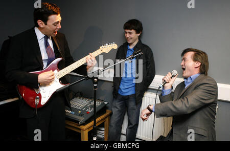 Kultursekretär Andy Burnham (links) und der britische Music Chief Executive Feargal Sharkey spielen Teenage Kicks während der Eröffnung eines professionell ausgestatteten, staatlich finanzierten Musikprobenraums in Knoetty Ash, Liverpool. Stockfoto