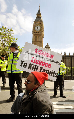 Ein tamilischer Protestler, der einen Waffenstillstand in Sri Lanka fordert, demonstriert in der Nähe des Parliament Square im Zentrum von London. Die Polizei sagte, dass große Massen von Demonstranten durch Polizeilinien stiegen und auf mehrere Straßen in Westminster, im Zentrum von London, überströmten. Stockfoto