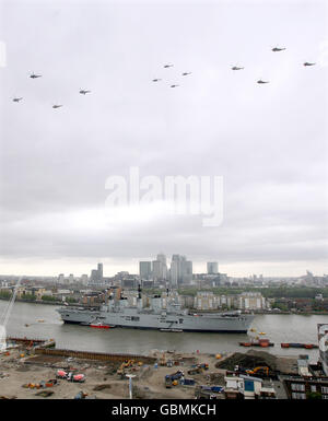 HMS illustre vor Anker in der Themse in Greenwich, London, als Hubschrauber über dem Kopf fliegen. Die Royal Navy feiert 100 Jahre Schiffsluftfahrt mit dem Flipper über dem Flaggschiff. Stockfoto