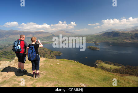 Spaziergänger machen ein Foto von Cat Bells Fell und schauen hinüber Derwent Wasser in Richtung Keswick im Lake District Stockfoto