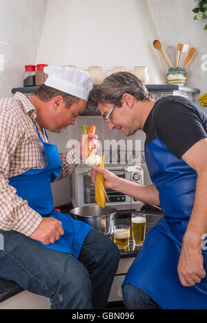 Zwei nicht sehr geschickt Männer versuchen, Spaghetti Kochen Stockfoto