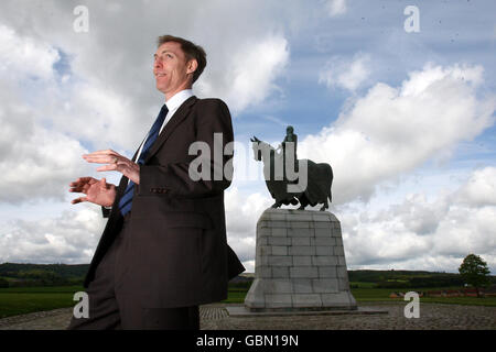 Der schottische Sekretär Jim Murphy an der Robert the Bruce Statue am Schlachtfeld von Bannockburn besucht das Touristenzentrum von Bannockburn, um herauszufinden, wie sich die Rezession auf die Besucherzahlen auswirkt, und trifft Kinder und Lehrer der Kellands School in Inverurie. Stockfoto