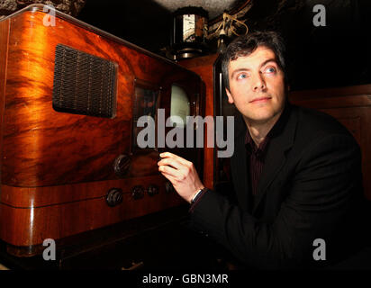 Iain Logie Baird, der Enkel von John Logie Baird, der den ersten Fernseher erfand, mit einem 1938 HMV 905 Fernseher mit digitaler Set-Top-Box in Musselburgh. Stockfoto