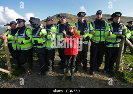 Die Shell to Sea-Aktivistin Maura Harrington lehnt sich an Gardai im Shell-Werk am Strand von Glengad in Co Mayo, Irland. Stockfoto