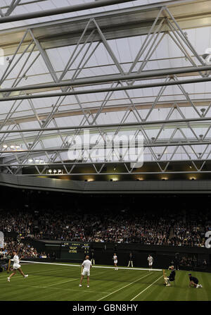 Steffi Graf (links) im Einsatz mit Partner und Ehemann Andre Agassi auf dem Mittelfeld bei einem Ausstellungsspiel gegen den Briten Tim Henman und seinen Partner Kim Clijsters während der Centre Court-Veranstaltung im All England Lawn Tennis and Croquet Club, Wimbledon, London. Stockfoto